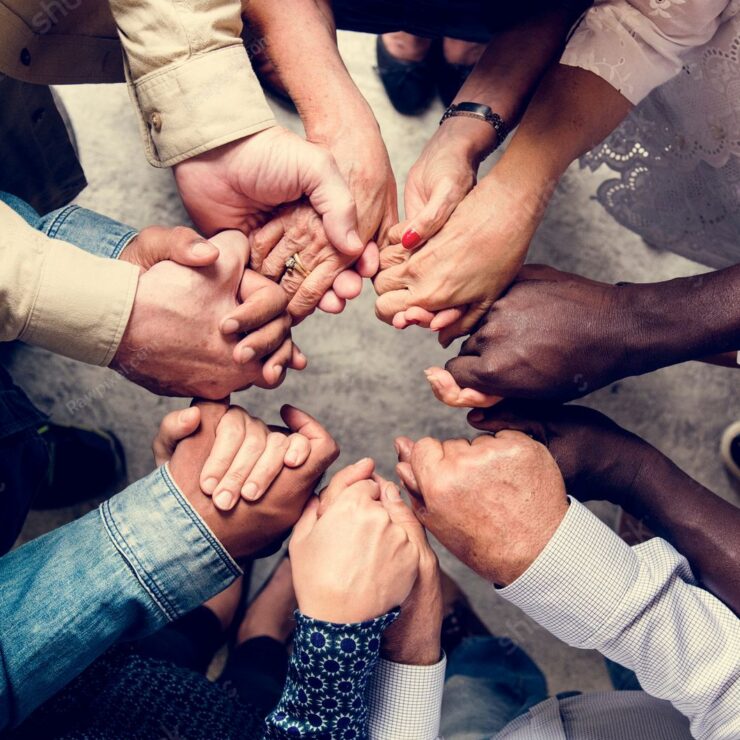 stock-photo-group-of-diverse-hands-holding-each-other-support-together-teamwork-aerial-view-1074714476